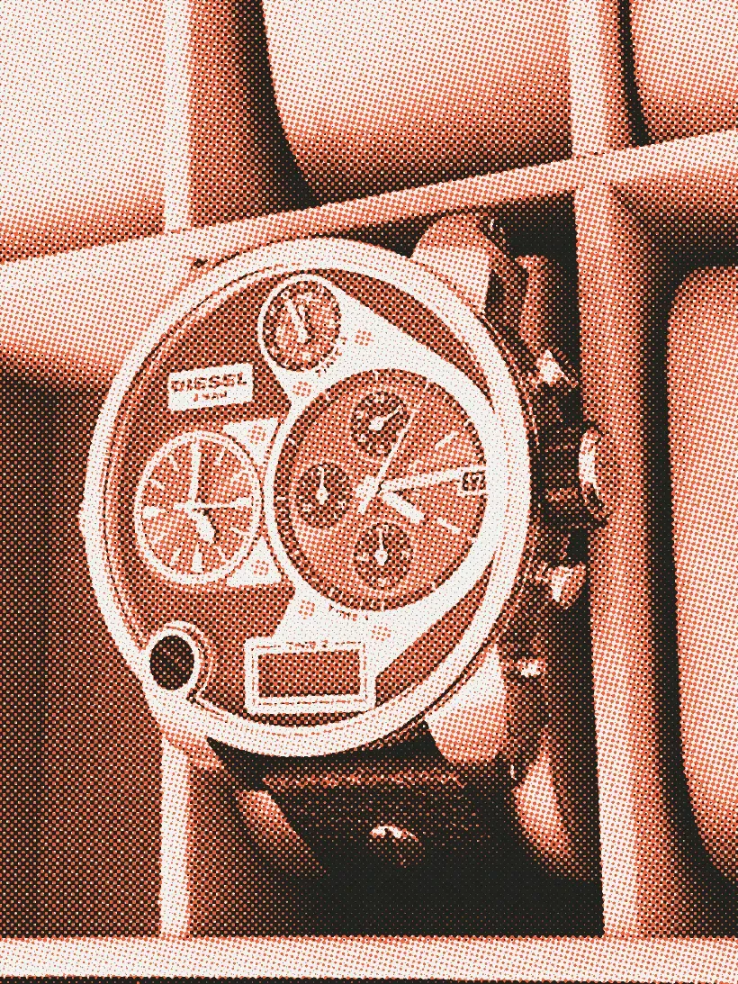 An oversized Diesel chronograph with a rose gold case, several subdials and a black leather strap, sitting in a gray watch box