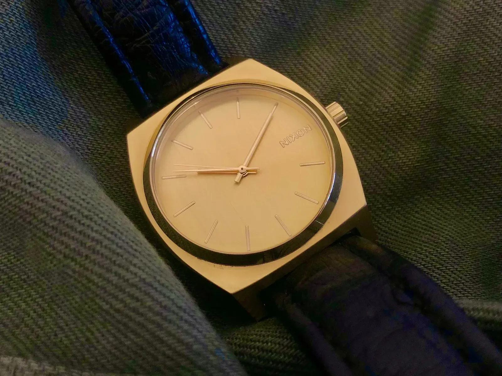 The Time Teller from above on a dark strap, resting on camouflage fabric